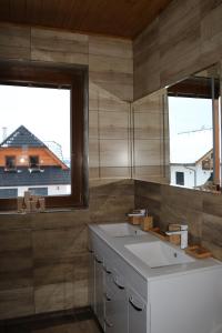 uma cozinha com 2 janelas e um lavatório branco em Pinus Cembra em Stará Lesná