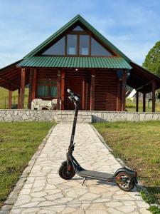 una moto está estacionada frente a una casa en Planinska tišina Guest House, en Plužine