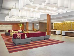 hol z kanapami i stołami oraz dużym żyrandolem w obiekcie DoubleTree by Hilton West Edmonton w mieście Edmonton