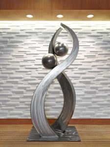 una escultura de metal de una mujer con dos bolas en DoubleTree by Hilton West Edmonton, en Edmonton