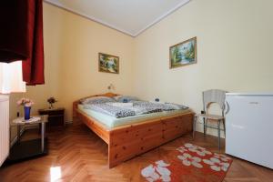 um quarto com uma cama e um frigorífico em Balaton Panzió em Siófok