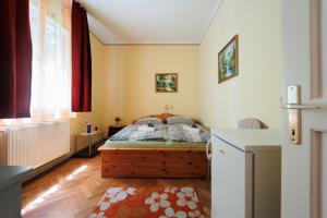 um pequeno quarto com uma cama e uma janela em Balaton Panzió em Siófok