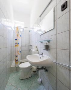 uma casa de banho com um lavatório, um WC e um espelho. em Balaton Panzió em Siófok