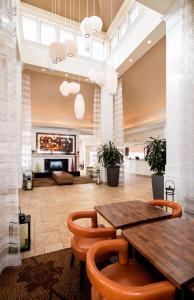 a large lobby with a wooden table and chairs at Hilton Garden Inn West Edmonton in Edmonton