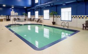 a large swimming pool in a building with blue walls at Hilton Garden Inn West Edmonton in Edmonton