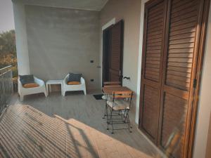 a balcony with two chairs and a table and a door at B&B Il Castello in Sangineto