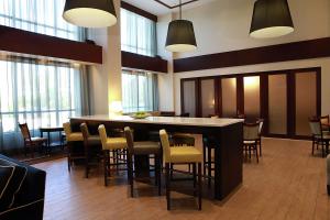 a lobby with a bar with chairs and windows at Hampton Inn & Suites Laval in Laval