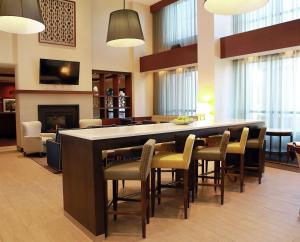 a lobby with a bar with chairs and a fireplace at Hampton Inn & Suites Laval in Laval