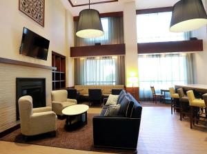 a lobby with couches and chairs and a fireplace at Hampton Inn & Suites Laval in Laval