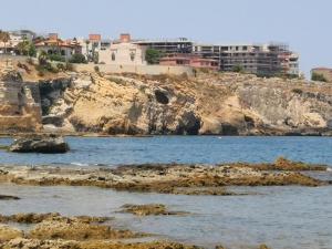 a body of water with buildings on a cliff at Alla Corte di Dionisio in Siracusa