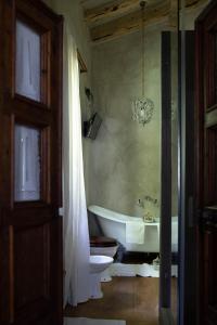 a bathroom with a tub and a toilet and a sink at La Criolda Charming Villa in San Felice del Benaco