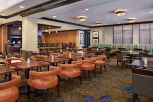 une salle à manger avec des tables et des chaises en bois dans l'établissement Hilton Garden Inn Toronto Airport West/Mississauga, à Mississauga