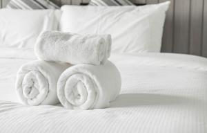 a pile of towels sitting on top of a bed at Aparthotel Madeleine in Antananarivo