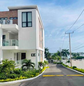 a white building on the side of a street at Apt 6ix - Modern and Airy @ Paradise Bay in Montego Bay