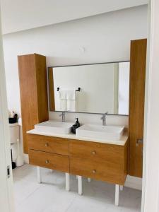 a bathroom with two sinks and a large mirror at Apt 6ix - Modern and Airy @ Paradise Bay in Montego Bay