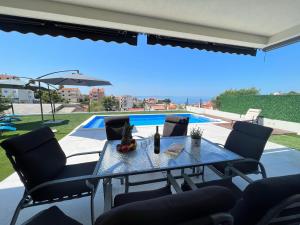 una mesa y sillas con vistas a la piscina en Villa La Vie - peacefull oasis with pool en Podstrana