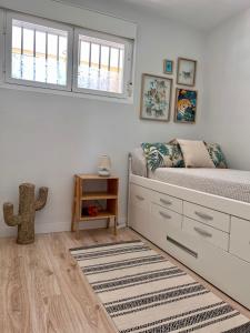 ein weißes Schlafzimmer mit einem Bett und einem Fenster in der Unterkunft Suite Bonalba in Alicante
