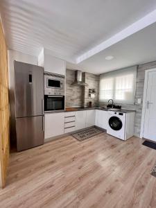 eine Küche mit Küchengeräten aus Edelstahl und Holzböden in der Unterkunft Suite Bonalba in Alicante
