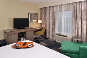 a hotel room with a bed and a desk with a television at Hampton Inn Broussard-Lafayette in Broussard