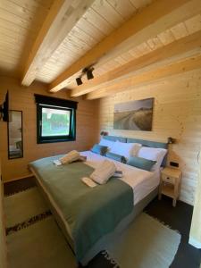 una camera da letto con un grande letto in una camera in legno di River House Moon a Gospić