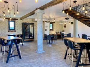 a large room with tables and chairs and a room with exposed ceilings at Le Domaine de Darracq in Arsagne