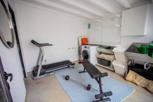 una habitación con un gimnasio con cinta de correr y una cocina en Casa na Curva - Artists Corner Country house en Lagos