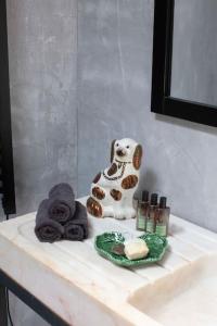 a figurine of a dog sitting on a bathroom sink at Casa na Curva - Artists Corner Country house in Lagos