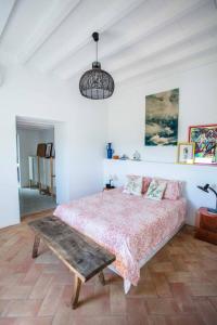 1 dormitorio con cama y banco. en Casa na Curva - Artists Corner Country house, en Lagos