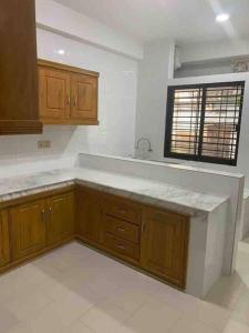 an empty kitchen with wooden cabinets and a window at *NEW BUILD* Luxury Holiday Home in Sylhet