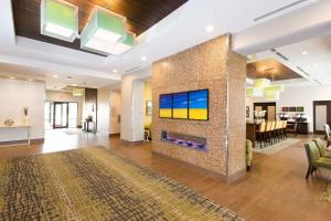 a lobby with a fireplace with a tv on a wall at Hampton Inn by Hilton Lloydminster in Lloydminster