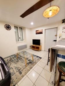 a living room with a table and a tv at Appartements T2 in Tarbes