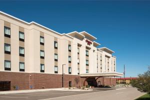 um grande hotel branco com um edifício de tijolos vermelhos em Hampton Inn Kalamazoo em Kalamazoo