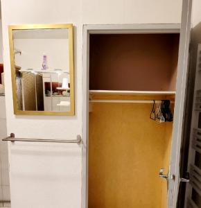 uma porta que leva a um quarto com um espelho em Appartements T2 em Tarbes