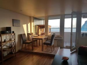 ein Wohnzimmer mit einem Tisch und Stühlen sowie eine Küche in der Unterkunft Ferienwohnung `Ton Utkiek` in Bremerhaven