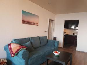 ein Wohnzimmer mit einem blauen Sofa und einem Tisch in der Unterkunft Ferienwohnung `Ton Utkiek` in Bremerhaven