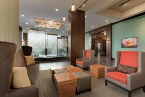sala de estar con sofá, sillas y mesa en Embassy Suites by Hilton Chicago Naperville, en Naperville