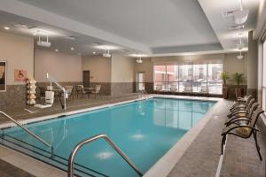 內珀維爾的住宿－Embassy Suites by Hilton Chicago Naperville，游泳池位于酒店房间,周围设有椅子