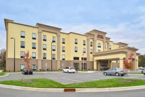a large yellow building with cars parked in a parking lot at Hampton Inn & Suites Shelby, North Carolina in Shelby