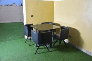 a table and chairs in a room with green carpet at Residence Patricia in Cotonou