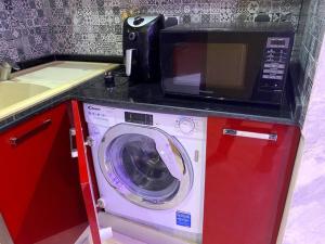 a microwave and a washing machine in a kitchen at Residence Patricia in Cotonou