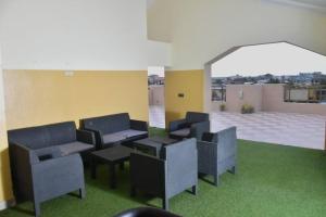 a group of chairs in a room with green grass at Residence Patricia in Cotonou