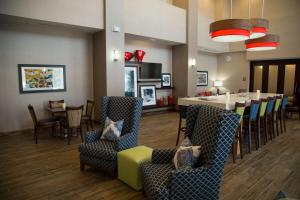 a dining room with a table and chairs and a kitchen at Hampton Inn and Suites by Hilton McKinney in McKinney