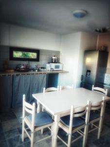 - une cuisine avec une table blanche et des chaises dans l'établissement Couleur pastel, à Saint-Louis