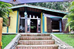 una casa amarilla con escaleras delante en Eco Chalés Luar das Marés en Ubatuba