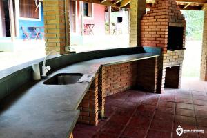a kitchen with a sink in a brick wall at Eco Chalés Luar das Marés in Ubatuba