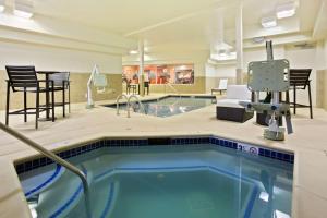 a swimming pool with a chair in a hotel room at Homewood Suites by Hilton Denver West - Lakewood in Lakewood