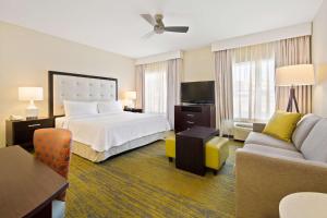 une chambre d'hôtel avec un lit et un canapé dans l'établissement Homewood Suites by Hilton Denver West - Lakewood, à Lakewood