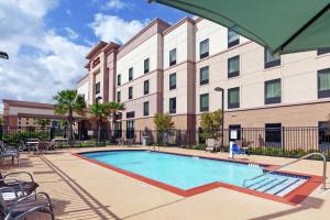 a swimming pool in front of a large building at Hampton Inn & Suites Houston North IAH, TX in Houston