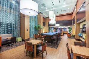 uma sala de jantar com mesas e cadeiras num restaurante em Hampton Inn & Suites Houston North IAH, TX em Houston