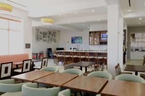 un restaurante con mesas y sillas de madera y un bar en Hilton Garden Inn Hickory, en Hickory
